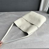 Ivory cowhide leather tote bag with two front pockets on marble surface