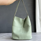 Sage green cowhide leather tote bag with two front pockets and minimalist bucket design