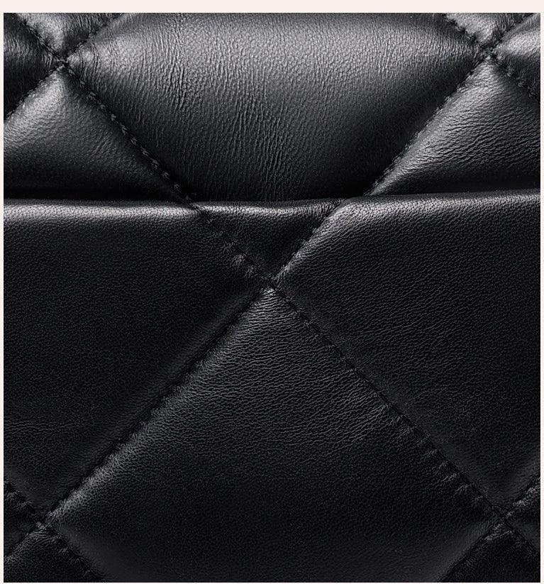 Close-up of black quilted genuine leather with diamond stitching, luxury bag texture