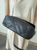 Quilted black genuine leather shoulder bag with gold chain strap shown from the bottom