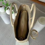 Top view of a beige leather tote bag with gold hardware, zippered pouch, and adjustable strap.