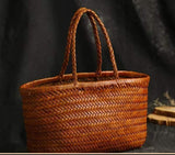Handmade brown woven Italian leather tote bag with double handles on dark background