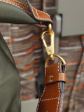 Close-up of nylon and cowhide tote bag strap with gold hardware and detailed stitching