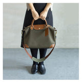 Woman holding olive waterproof nylon and cowhide tote bag with leather handles and strap