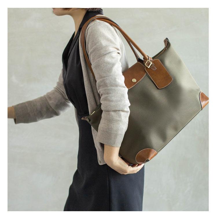 Woman carrying olive green nylon tote bag with brown leather handles and accents