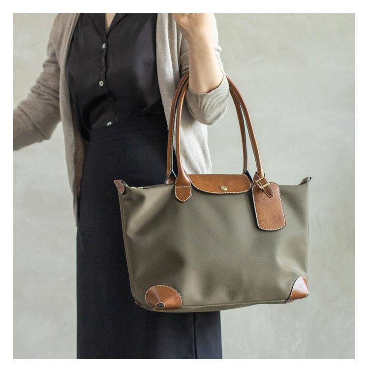 Woman carrying an olive green nylon and brown cowhide leather tote shoulder bag