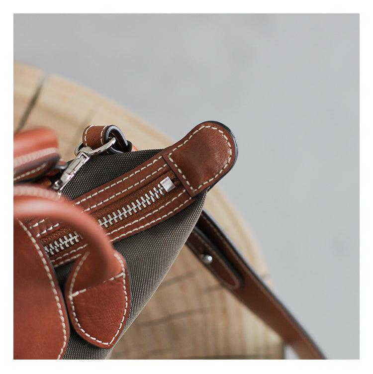 Close-up of brown leather and nylon tote bag with zipper and contrast stitching detail