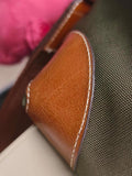 Close-up of brown cowhide leather and green waterproof nylon tote bag with detailed stitching