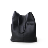 Black cowhide leather tote bag with two front pockets and minimalist design on white background
