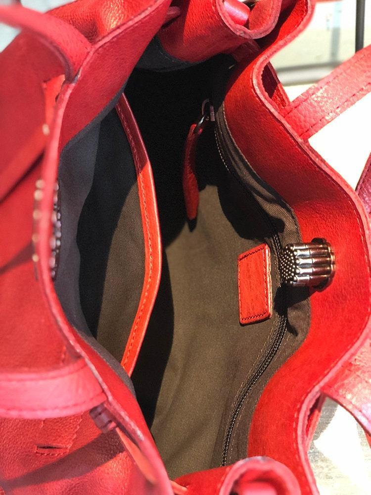 Interior of red leather women’s shoulder bag with zipper pocket and spacious compartment