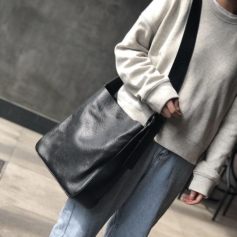 Full grain leather shoulder bag with wide strap worn crossbody, casual outfit, street style