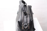 Black genuine leather handbag with dual zippers and top handle on white background