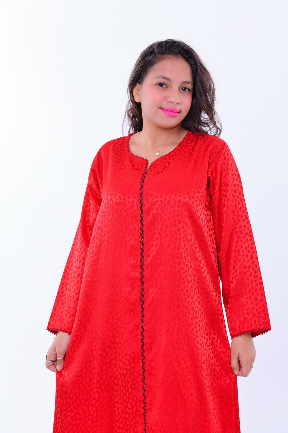 Woman in red silk boho kaftan dress with black trim and wide sleeves, resort wear style