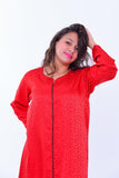 Woman wearing a red silk boho kaftan dress with wide sleeves and subtle ethnic pattern