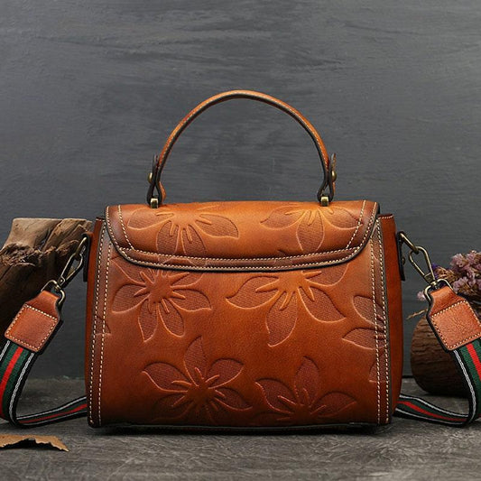Handcrafted full grain leather handbag with embossed floral pattern and detachable striped strap