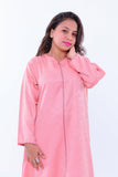Woman wearing a pink handcrafted kaftan with subtle patterns and long sleeves