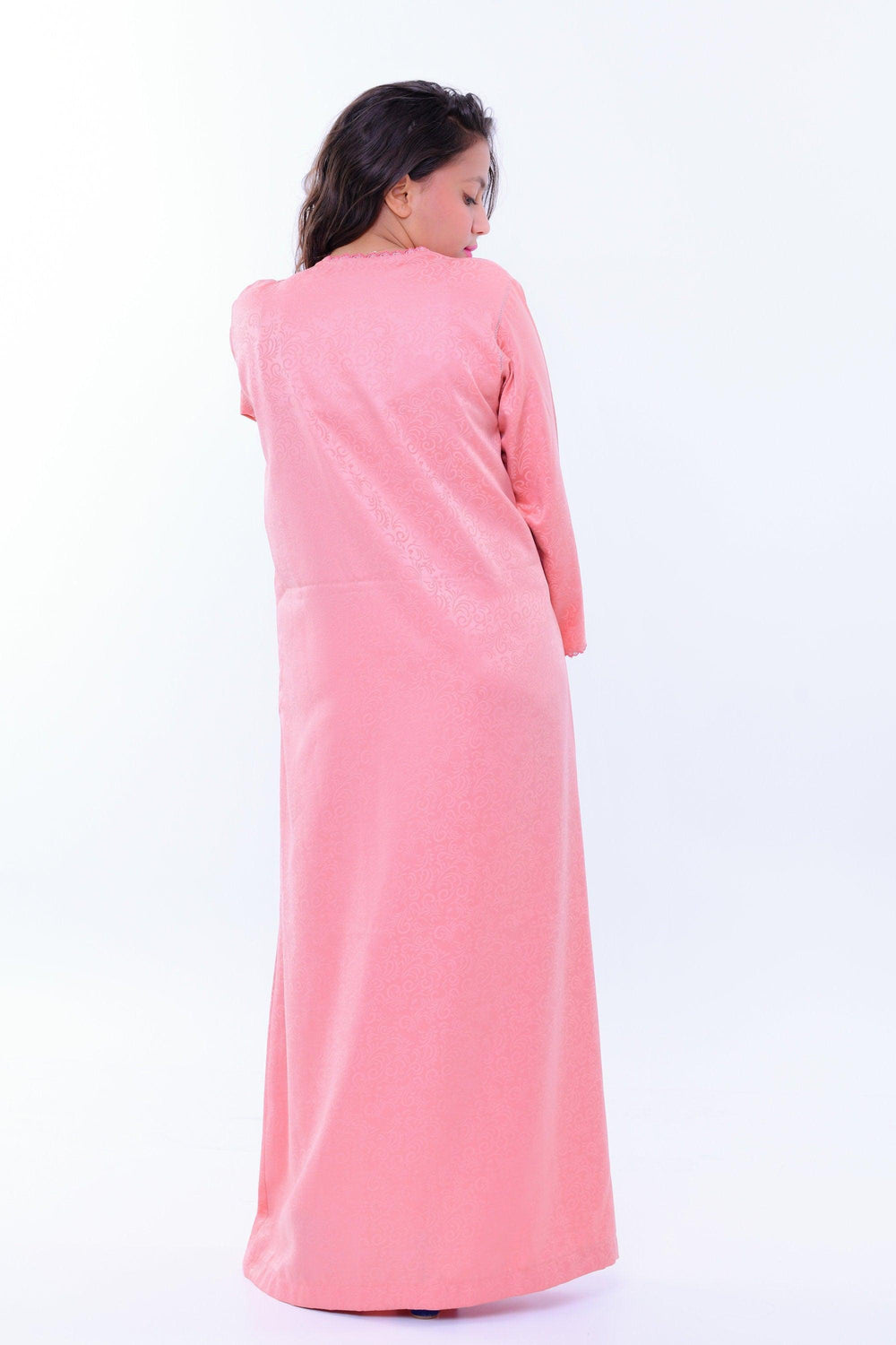 Woman modeling light pink long sleeve kaftan dress with subtle pattern, back view