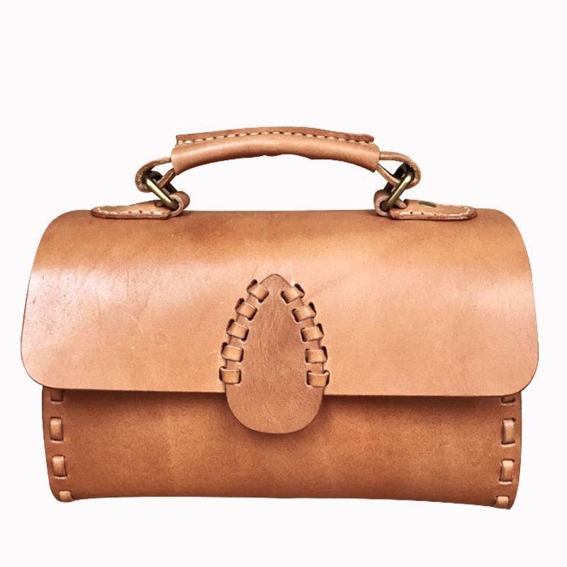 Handcrafted tan leather shoulder bag with handle and visible stitching on white background