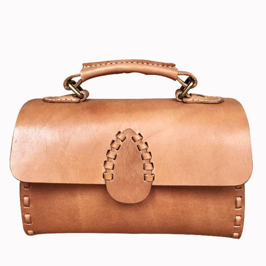Handcrafted tan leather shoulder bag with handle and visible stitching on white background
