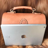 Handcrafted tan leather shoulder bag with top handle and stitched detail, shown with iPad for size reference.