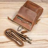 Handcrafted full grain leather crossbody bag with zipper pockets and detachable strap on wood