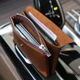 Handcrafted minimalist leather slim wallet for women with zipper, open displaying cards and cash.