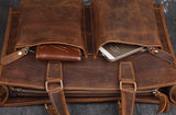 Handmade full grain leather messenger bag with front pockets, holding a wallet and smartphone