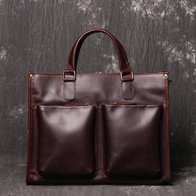 Dark brown full grain leather messenger bag with two large front pockets and top handles