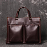 Dark brown full grain leather messenger bag with two large front pockets and top handles