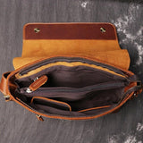Open handmade brown cowhide leather shoulder bag with multiple compartments and zipper pockets