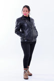 Woman wearing a black genuine leather slim-fit biker jacket with zip pockets.