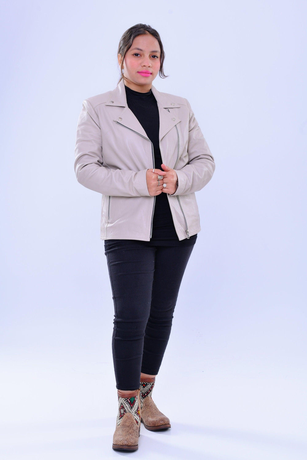 Woman wearing slim fit grey genuine leather biker jacket, black outfit, patterned boots