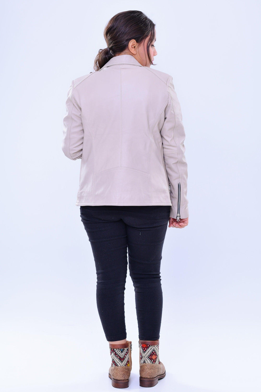 Woman wearing slim fit grey genuine leather biker jacket, back view, with patterned boots