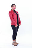 Woman wearing slim fit red genuine leather biker jacket, black pants, patterned ankle boots, standing against white background.