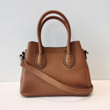 Brown leather handbag with double top handles and adjustable shoulder strap on white background