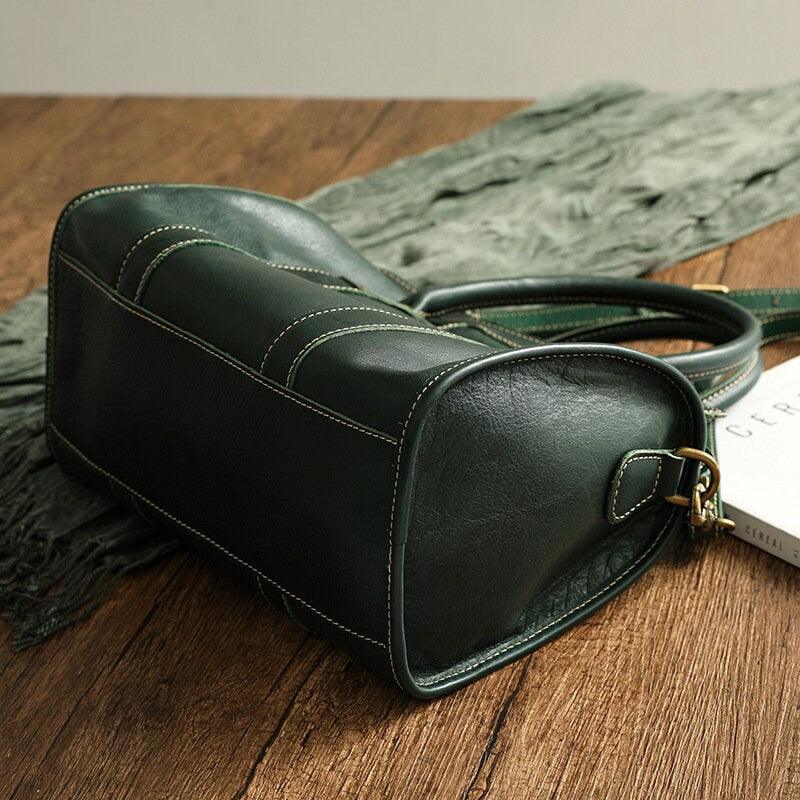 Large green cowhide leather handbag with contrast stitching on wooden surface