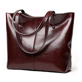 Large burgundy leather tote bag with double stitched handles on white background