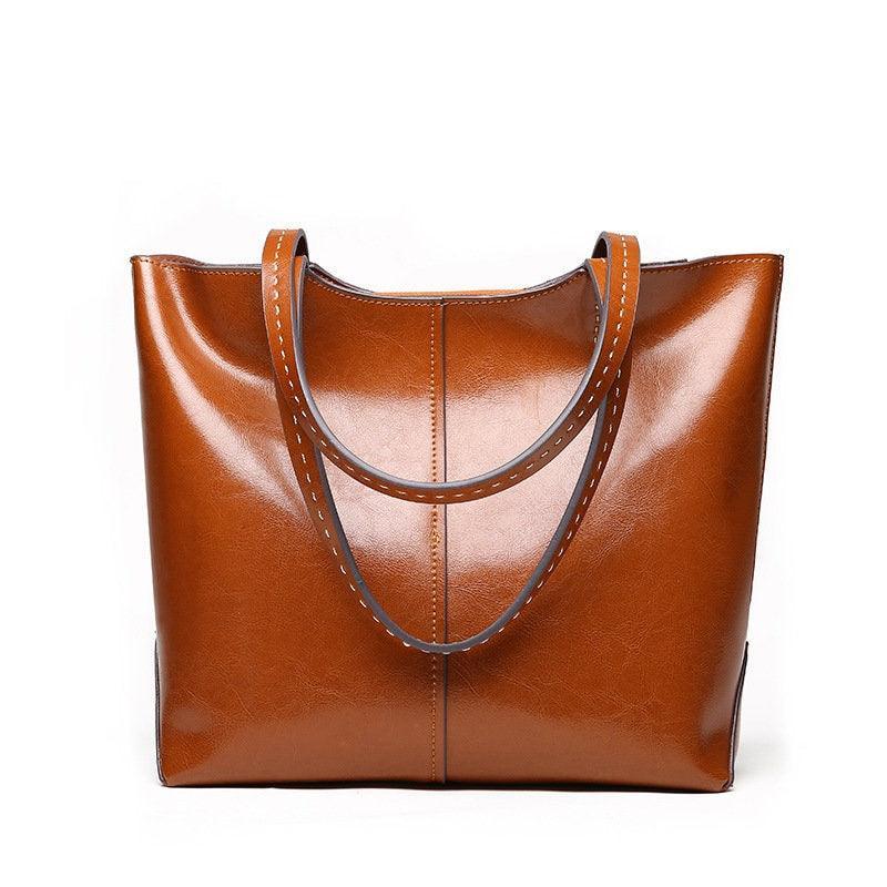 Brown leather tote bag with double handles, simple and classic design, studio background