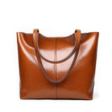 Brown leather tote bag with double handles, simple and classic design, studio background