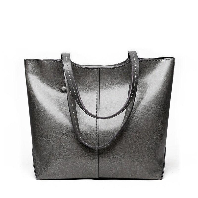 Large gray leather tote bag with simple design and double handles on a white background.