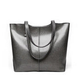Large gray leather tote bag with simple design and double handles on a white background.