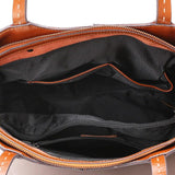 Interior view of a brown leather tote bag with black fabric lining and zipper pockets
