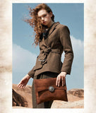 Woman holding large handcrafted brown leather clutch bag with decorative clasp outdoors