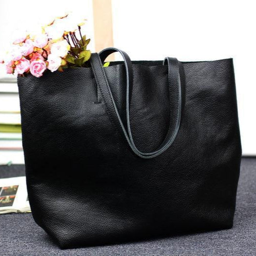 Large black full grain leather tote bag with double handles, pink flowers inside