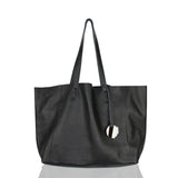 Black full grain leather tote bag with double handles and hanging keychain on white background