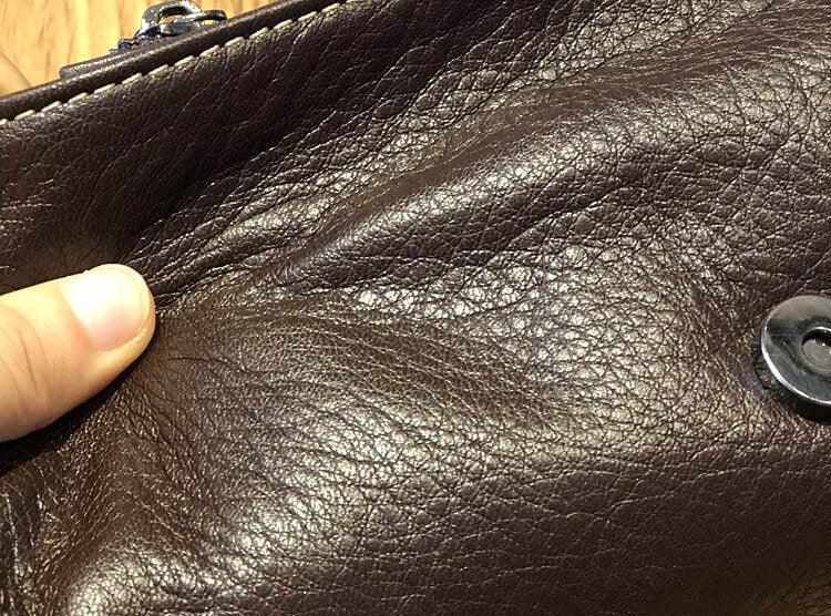 Close-up of brown genuine leather crossbody bag with magnetic snap closure
