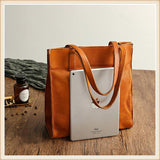 Natural Italy cowhide leather tote bag with dual straps, shown with iPad for size reference on wooden table.