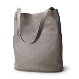 Oak cowhide leather tote bag with two front pockets, soft minimalist design, neutral background