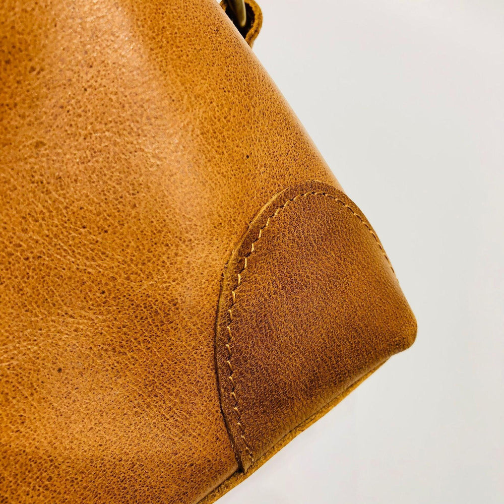 Close-up of brown genuine leather bag corner with fine stitching detail