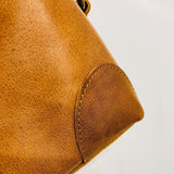 Close-up of brown genuine leather bag corner with fine stitching detail